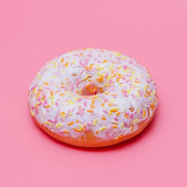 pembe bir arka planda beyaz buzlanma ile donut. Bir donut serpilir
