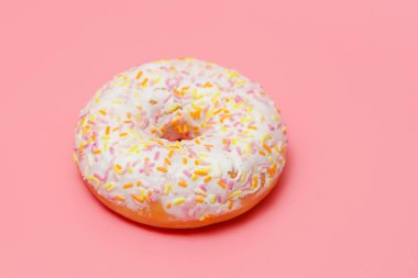 pembe bir arka planda beyaz buzlanma ile donut. Bir donut serpilir