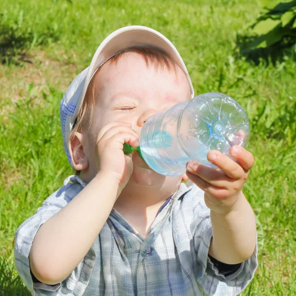 Çocuk bir şişeden su içiyor. Çocuk, çocuk, bastırıyor