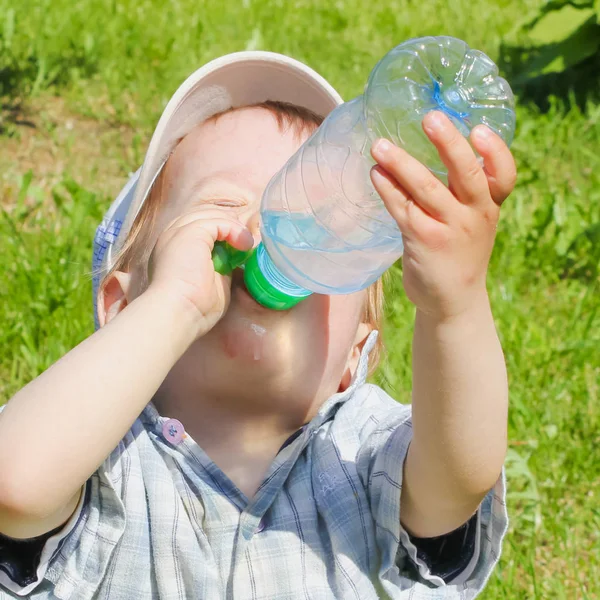 Çocuk bir şişeden su içiyor. Çocuk, çocuk, bastırıyor