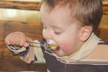 Çocuk yemek yerken kirli. Çocuk yiyor. Biraz