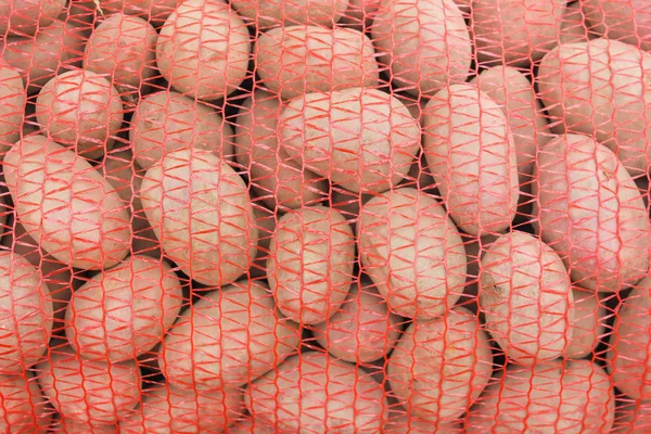 Potatoes in bags close-up. Grids with potatoes. sale of potatoes