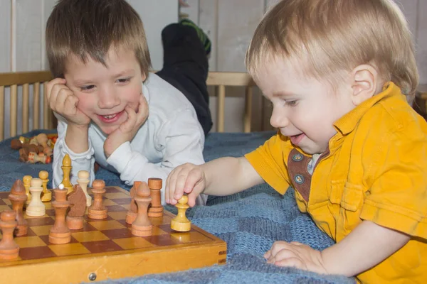 Los niños juegan al ajedrez. El desarrollo de la lógica, el pensamiento lógico . Fotos De Stock