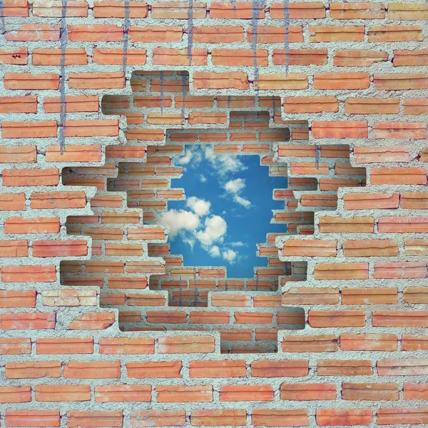 Tuğla duvar arka planında mavi gökyüzü deliği