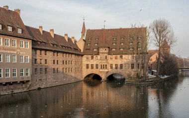 Nürnberg, Almanya - 04 Mart 2018: Heilig-Geist-Spital (Kutsal Srit'in Bakımevi) Eski Şehir Nürnberg'de. Pegnitz Nehri üzerindeki Müze Köprüsü'nden görünüm - Nürnberg, Bavyera - Almanya