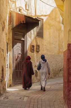 Meknes, Fas - 18 Şubat 2017: Fas'ın Meknes kentinde ki sokakta yürüyen kimliği belirsiz kadınlar. Meknes Fas'ın dört İmparatorluk şehrinden biridir.