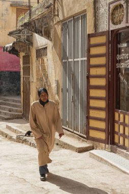 Meknes, Fas - 18 Şubat 2017: Fas'ın Meknes kentinde ki sokakta yürüyen kimliği belirsiz kadın. Meknes Fas'ın dört İmparatorluk şehrinden biridir..