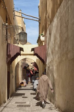 Meknes, Fas - 18 Şubat 2017: Fas'ın Meknes kentinde ki sokakta kimliği belirsiz kişiler yürüyor. Meknes Fas'ın dört İmparatorluk şehrinden biridir.