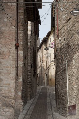 Umbria bölgesinde güzel küçük bir kasabanın tarihi merkezinde muhteşem geleneksel İtalyan ortaçağ sokak (Perugia), Orta İtalya
