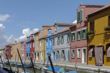 Burano, İtalya - 18 Nisan 2009: Burano, kanallarla dolu zarif bir küçük kasaba bir kanal önünde renkli binalar ve teknelerpanoramik görünümü