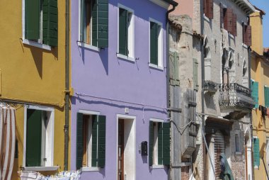 Burano, İtalya - 18 Nisan 2009: Venedik yakınlarındaki kanallarla dolu zarif bir kasaba olan Burano adasında renkli binalara sahip cadde