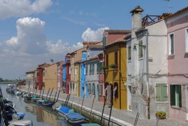 Burano - İtalya, 18 Nisan 2009: Burano, İtalya'da bir kanalın önünde renkli binaların, kimliği belirsiz kişilerin ve teknelerin panoramik manzarası