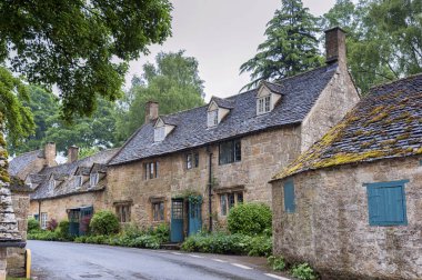 Snowshill, İngiltere - 27 Mayıs 2018: Sarı Cotswold kireçtaşı duvarlı ve tahta çatılı ve Snowshill, Cotswolds - İngiltere 'de çiçek ve gül bahçeli tipik güzel kır evleri
