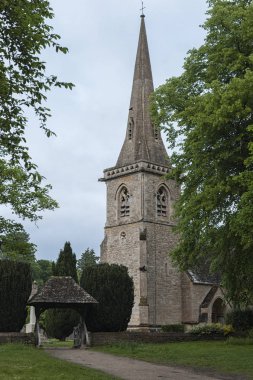 LOWER SLAUGHTER, COTSWOLDS, GLOUCESTERSHIRE, ENGLAND - MAY, 27 2018: Mary's Church with graveyard in the village of Lower Slaughter, Cotswolds, Gloucestershire, England, UK clipart