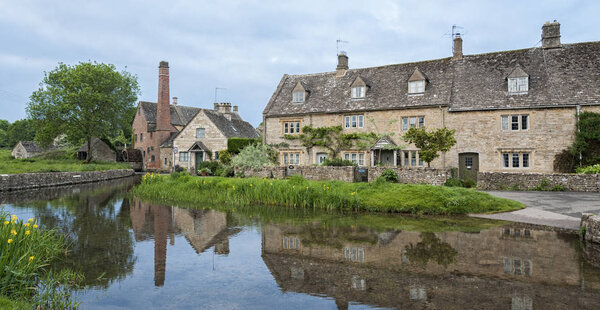 LOWER SLAUGHTER, COTSWOLDS, GLOUCESTERSHIRE, ENGLAND - MAY, 27 2018:  The Old Mill along the River Eye in the lovely village of Lower Slaughter, Cotswolds, Gloucestershire, England, UK,