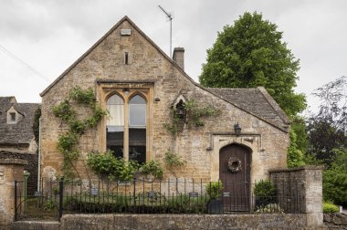 UPPER SLAUGHTER, COTSWOLDS, GLOUCESTERSHIRE, ENGLAND - MAY, 27 2018: The Old School House in the beautiful and pretty village of Upper Slaughter in the Cotswolds region - Gloucestershire, UK clipart