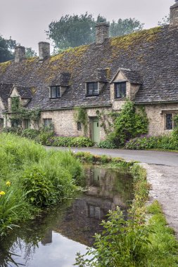 Bibury, Cotswolds, Uk - 28 Mayıs 2018: Dünyaca ünlü Arlington Row, Bibury, Gloucestershire, İngiltere 'de kendine özgü sarı kireçtaşından yapılmış geleneksel kır evleri   