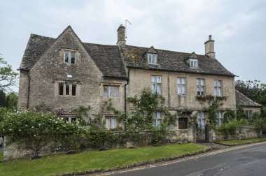 BIBURY, COTSWOLDS, UK - MAY 28, 2018: Traditional cotswold stone cottages built of distinctive yellow limestone in the lovely village of Bibury, Gloucestershire, England    clipart