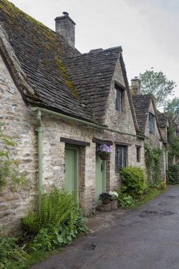 Bibury, Cotswolds, Uk - 28 Mayıs 2018: Dünyaca ünlü Arlington Row, Bibury, Gloucestershire, İngiltere 'de kendine özgü sarı kireçtaşından yapılmış geleneksel kır evleri   