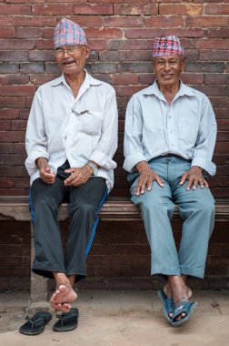 PATAN, LALITPUR, NEPAL - 15 Ağustos 2018: Tanımlanamayan Newari yaşlıları Patan Durbar Meydanı 'ndaki Mul Chowk Kraliyet Sarayı önünde oturuyorlar -