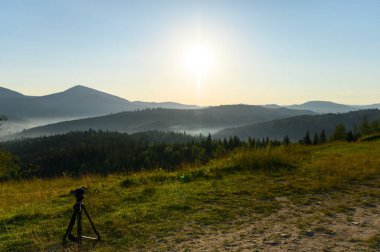Üç ayaklı kamerayla gün doğumu gökyüzü inanılmaz. Gökyüzü yansıması. Yaz mevsiminde güneş ve çam ağaçlarıyla birlikte güneş doğar. Kayalarla manzara, bulutlarla güneşli gökyüzü