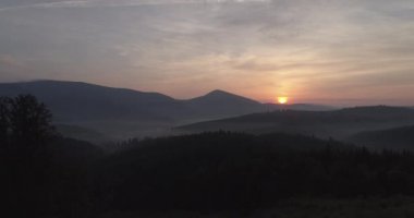 Dağlar, güneş ve çam ağaçlarıyla kaplı. Gün doğumu