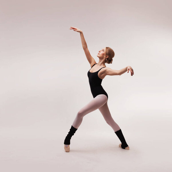 Ballerina in black outfit posing on toes