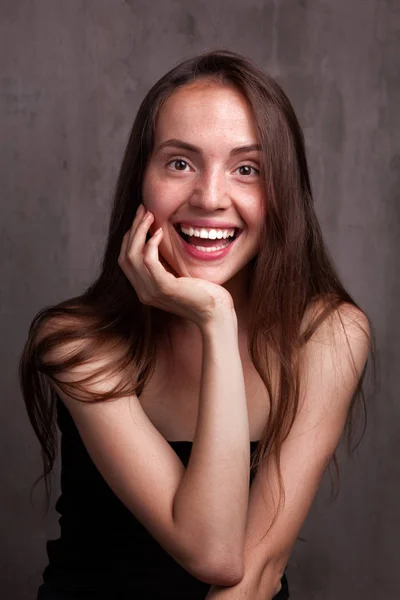 Sorrindo jovem mulher sobre fundo grunge cinza escuro — Fotografia de Stock