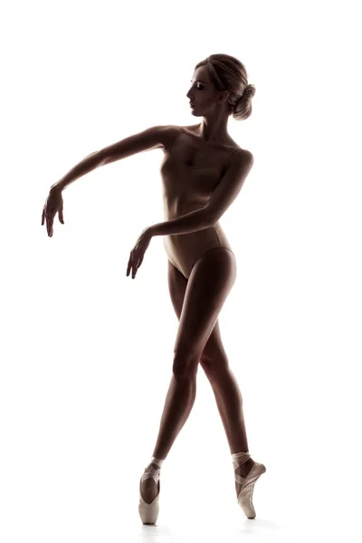 Балерина в бежевом наряде позирует на пальцах ног — стоковое фото