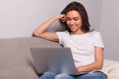 Evde dizüstü bilgisayarda çalışan bir kadın..