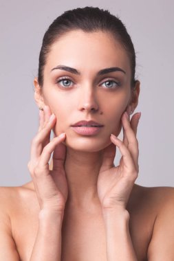 Temiz tenli, güzel bir kadının yakın plan portresi.
