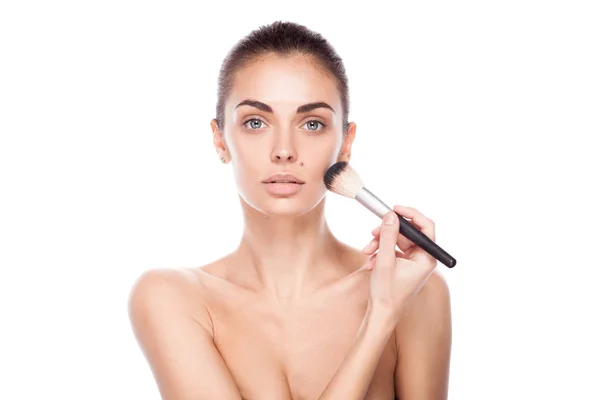 Porträtt av kvinna med makeup borste nära hennes ansikte — Stockfoto