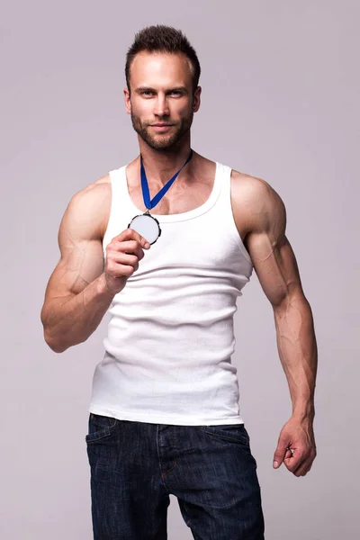 Портрет спортсмена в білій піджаці з медаллю чемпіонів — стокове фото