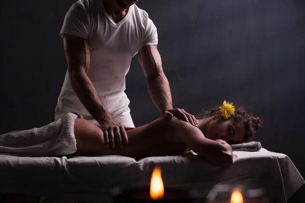 Massagista bonito fazendo massagem para mulher morena — Fotografia de Stock
