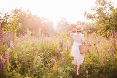 bir saman sepeti tutan arkadan kadın