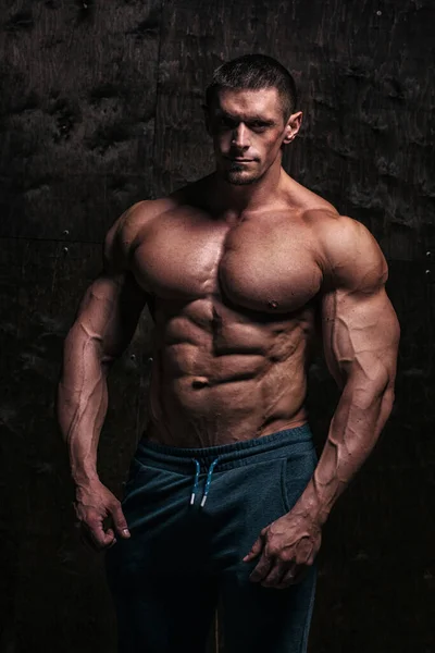 Sportlicher und gesunder muskulöser Mann mit dunklem Grunge-Hintergrund — Stockfoto