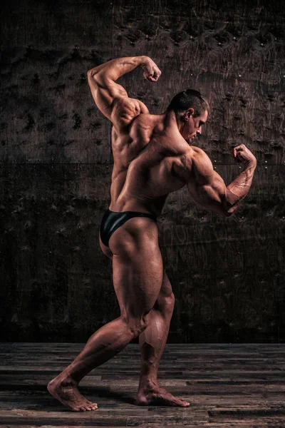 Sportlicher und gesunder muskulöser Mann mit dunklem Grunge-Hintergrund Stockbild
