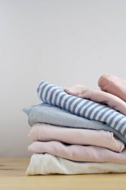 Elbise yığını. Kot pantolon, gömlek, elbise, kazak ahşap masa ve beyaz arka plan yalıtım