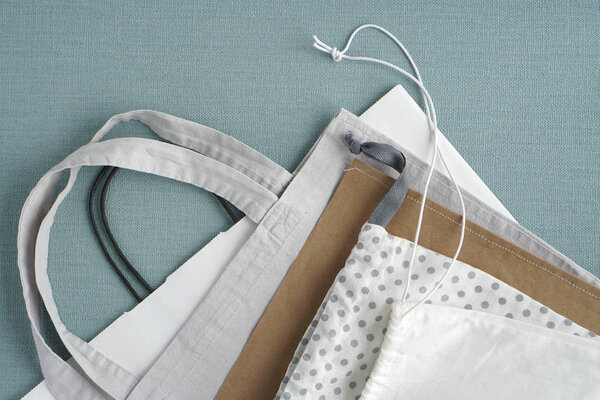 Сумки для покупок на синем фоне. Хлопок и бумажные пакеты для бесплатных пластиковых покупок
.