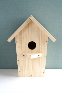 Mavi ve beyaz arka plan üzerinde ahşap kuş yuvası. Fotoğraf