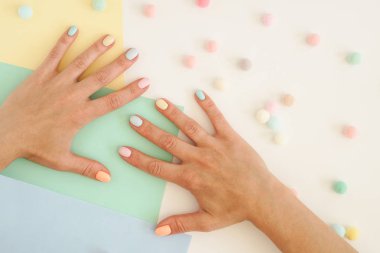 Şık trendy renk kadın manikür . Renkli kağıt arka planda kadınların elleri