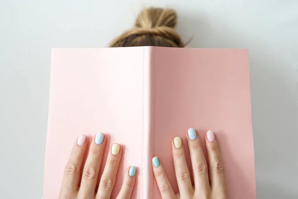 Elegante manicure feminino cor da moda. Mulheres s mãos manter rosa nota pad — Fotografia de Stock