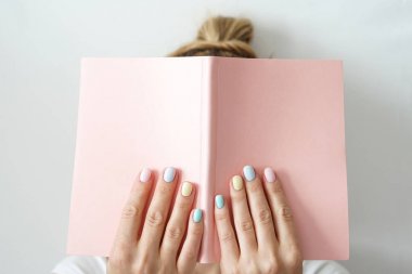 Şık trendy renk kadın manikür . Kadınların elleri pembe not defteri tutmak