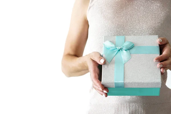 Donna in camicia scintillante tiene scatola regalo con nastro in mano — Foto Stock