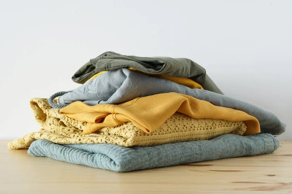 Stack of summer clothes on wooden table and white background isolation — Stock Photo, Image