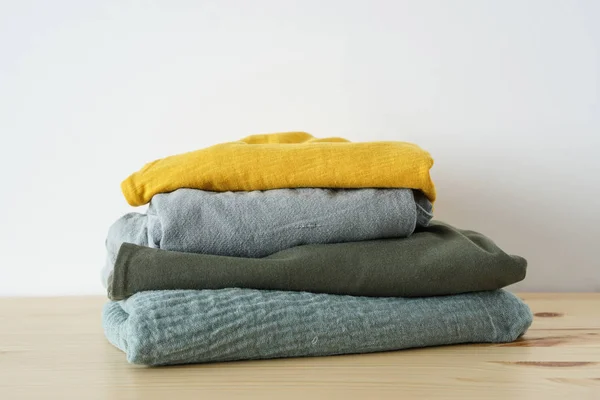 Stack of summer clothes on wooden table — Stock Photo, Image