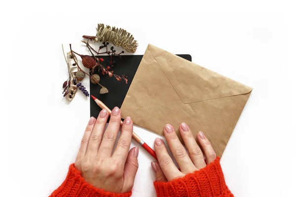 As mãos da mulher papel a lápis e envelope. Camisola vermelha — Fotografia de Stock
