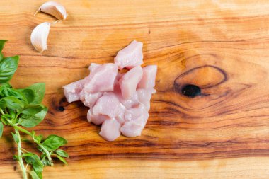 Otlar ile doğrama tahtası üzerinde Çiğ doğranmış tavuk