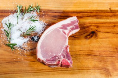Otlar ile doğrama tahtası üzerinde Ham domuz loin chop
