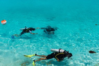 Dalgıçlar Maldivler sığ mavi suda öğrenme